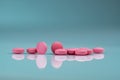 Round pink tablets pill on gradient background. Vitamins and minerals plus folic acid vitamin E and zinc in drug bottle