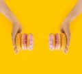 round pink and yellow appetizing glazed doughnuts with sprinkles on light-skinned hands flying on bright yellow background. Order