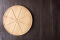 Round pizza cutting board with slice grooves on wooden table top view Royalty Free Stock Photo