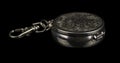 Round portable ashtray made of metal with patterns on the lid and with a carabiner for fastening