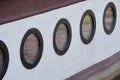 Round portholes on a river pleasure boat, shipboard, water reflection in the window, the old ship Royalty Free Stock Photo