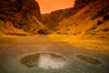 Round puddle and rain on a stony rocky mountain landscape of Iceland. Toned