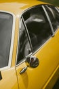 Round rear view mirror on a vintage yellow car Royalty Free Stock Photo