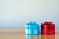 Round red and blue gift box with ribbon bow on wooden table with Royalty Free Stock Photo