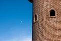 Round red brick block tower with round window in blue clear sky Royalty Free Stock Photo