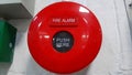 A round red fire alarm installed on the wall in the room Royalty Free Stock Photo