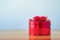 Round red gift box with ribbon bow on wooden table with copy spa Royalty Free Stock Photo