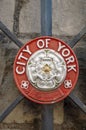 Round red and white (tudor or union rose) emblem of the City of York.