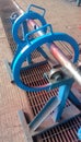 The round ring was painted blue and has started to dry on an iron stand outside the workshop