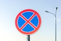 Round road sign with a red cross