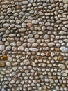 Round rocks stones used in natural looking facade wall or ground surface coverage glued in cement for natural look