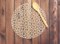 Round rope napkin or stand and spoon on a wooden rustic table. T