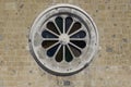 Round rose window in a yellow stone wall