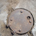 round rusty iron hatch in the concrete floor. Royalty Free Stock Photo
