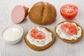 Round rye bread, sandwiches with sausage, tomatoes, mayonnaise,