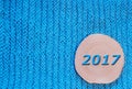 Round saw cut alder and blue date 2017 on blue knitted fabric b