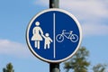 Round shaped blue and white road sign for pedestrian and bicycle zone mounted on metal pole