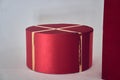 Round-shaped Christmas gift box in red packaging with ribbon. Side view, highlighted on a white background. With space Royalty Free Stock Photo
