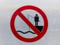 A white and red prohibition sign at the port. Fishing is prohibited here.