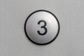Round silver push button with number 3 on metallic panel, simple control key on generic electronic device, keypad interface symbol Royalty Free Stock Photo