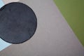 Round slate board arranged on simple colorful background with gray and blue and green papers