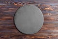 Round slate stand board a wooden background. space for text Royalty Free Stock Photo