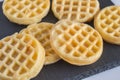 Round small waffles on black slate board with selective focus