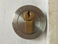 Round steel key hole from close up, old and rustic look, on an old white door