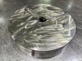Round steel plate broken into four pieces on a metal bench, cracked steel part