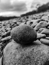 Round stone close-up. Nature. Against the background of a pile of river pebbles