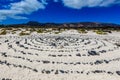 A round stone pattern in the sand by a beach