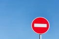 Round stop sign against a blue sky