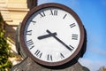 Round street iron clock with arrows.