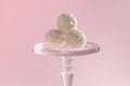 Round sweet candies in coconut flakes on a pink background, taste harmony, exquisite dessert, rafaello