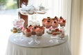 Round table with luxurious cupcakes and macaroons