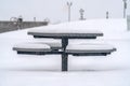 Round table with seats covered with snow in winter Royalty Free Stock Photo