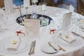 Round table served with empty plates, knives, forks, card and napkins, covered with white tableclothes. Cutlery, glassware on Royalty Free Stock Photo