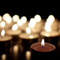 Many candles burning in darkness Royalty Free Stock Photo