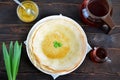 round thin pancakes with maple syrup on the table