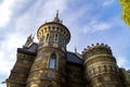 Round towers of a stone castle against a blue sky in the rays of the evening sun