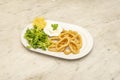 Round tray of Andalusian squid with some shoots of lamb\'s lettuce, lemon and mayonnaise