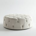 Round, tufted ottoman with a light beige fabric cover. The design features deep button- Royalty Free Stock Photo