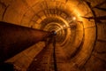 Round underground technical tunnel of heating duct with rusty pipeline Royalty Free Stock Photo