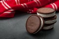 Round vanilla and cookie ice cream sandwich bar leaning against a stack of three ice cream sandwiches with copy space and a red Royalty Free Stock Photo