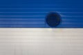 Round ventilation window with shutters on a dirty white blue metal wall with horizontal lines. rough surface texture Royalty Free Stock Photo