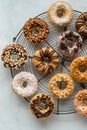 A round vintage cooling rack topped with assorted decorated homemade donuts.