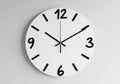 A plain light gray wall, the clock has a minimalist design, emphasizing Royalty Free Stock Photo