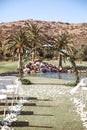 Round wedding arch with eucalyptus leaves, blue hydrangea flowers with waterfall and mountains. Outdoor wedding ceremony