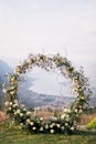 Round wedding arch stands on a mountain overlooking the sea valley