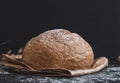 Round white bread on a paper bag on a black table. Royalty Free Stock Photo
